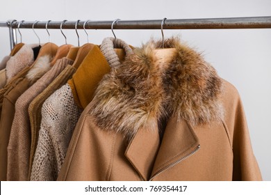Row of women leather coat and jacket with sweater on hangers isolated
