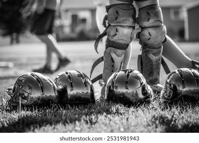 Row of youth girl baseball helmets in the grass with a defocused field in the background. - Powered by Shutterstock