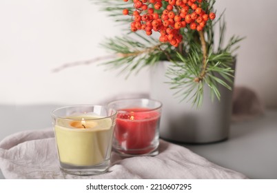 Rowanberry And Pine Branch In A Concrete Vase And Glowing Candles On Grey Background. Blog Autumn Content, Thanksgiving Home Decor