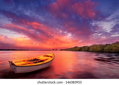 A rowboat watches an amazing sunset - Powered by Shutterstock