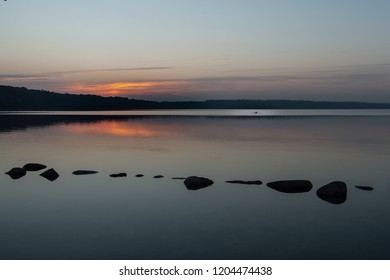 Rower Heading Home As The Very Last Rays Of Sun Hit The Lake.