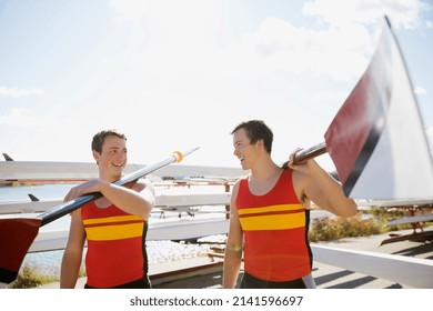 Rowers carrying oars at waterfront - Powered by Shutterstock