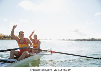 Rowers celebrating in scull on sunny river - Powered by Shutterstock