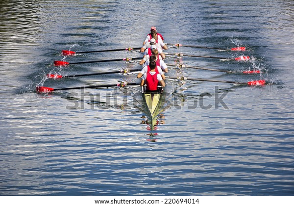 Rowers in\
eight-oar rowing boats on the tranquil\
lake