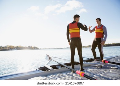 Rowers slapping hands at waterfront - Powered by Shutterstock