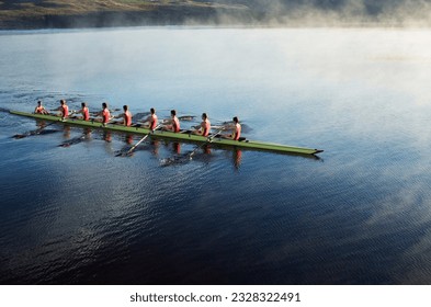 Rowing crew rowing scull on lake