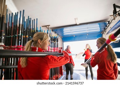 Rowing team carrying oars in boathouse - Powered by Shutterstock