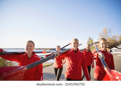 Rowing team carrying oars at waterfront - Powered by Shutterstock