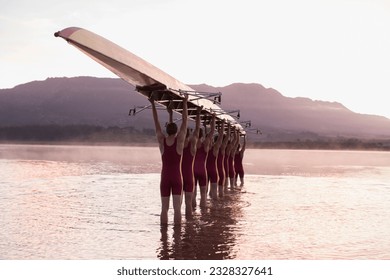 Rowing team carrying row boat overhead in still lake - Powered by Shutterstock