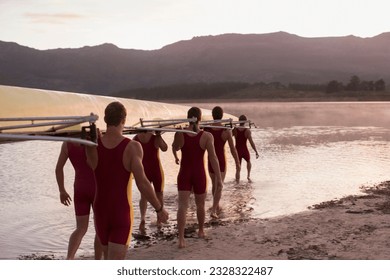 Rowing team carrying scull into lake at dawn - Powered by Shutterstock