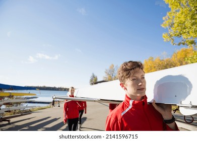 Rowing team carrying scull at waterfront - Powered by Shutterstock