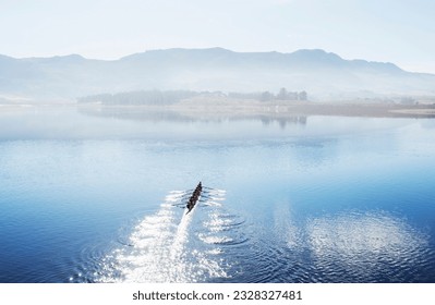 Rowing team rowing scull on lake - Powered by Shutterstock