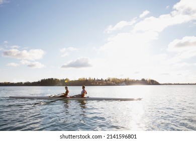 Rowing team in scull on sunny river - Powered by Shutterstock