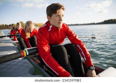 Rowing team in scull at waterfront - Powered by Shutterstock