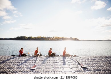 Rowing team in scull at waterfront - Powered by Shutterstock