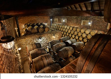Rows of alcohol barrels in stock. Distillery. Cognac, whiskey, wine, brandy. Alcohol in barrels