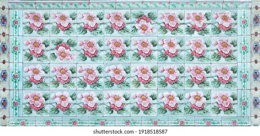 Rows of antique Nyonya Tiles with pink flowers with green background. Vintage Baba and Nyonya style floral tile pattern in penang. Traditional Peranakan cultural in Malaysia.