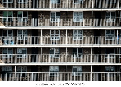 Rows and rows of balconies on a brown stone building, lined with white railings. - Powered by Shutterstock