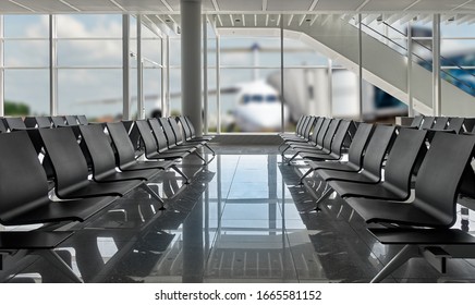 Rows of black chairs at airport and plane standing, There is a path for all windows - Shutterstock ID 1665581152