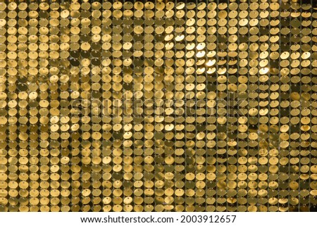 rows of blinking golden yellow brass metal plaques sway in wind and shines in sun and create unique pattern of movement. round reflective particles texture glitter under waves of wind. Spangle Glitter