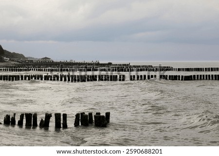 Rows of breakwaters driven into the seabed protect the coast from the damaging effects of waves on the Baltic Sea coast as seen from Ustronie Morskie, Poland.