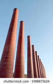 Rows Of Brick Smoke Stack Against A Blue Sky Background.