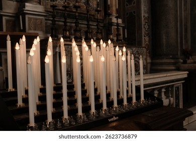Rows of burning white devotional candles in Saint Peters Basilica symbolizing prayer spiritual reflection and quiet contemplation in Vatican City. High quality photo
