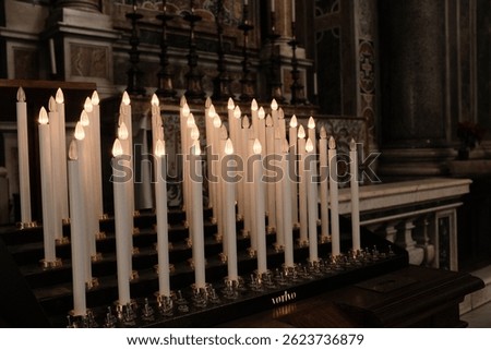 Rows of burning white devotional candles in Saint Peters Basilica symbolizing prayer spiritual reflection and quiet contemplation in Vatican City. High quality photo