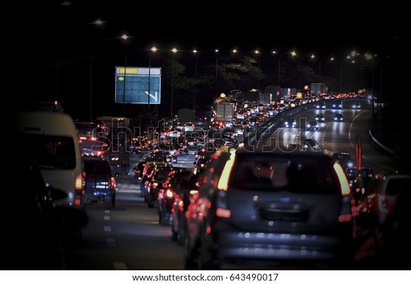 Rows of cars stuck in traffic jams on the highway\
road at the night..