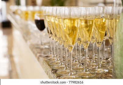 Rows of champagne flutes on bar counter, shallow focus