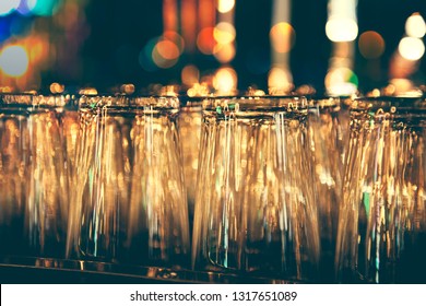 Rows Of Clean Empty  Beer Or Water  Glasses Turn Upside Down On Counter Bar
With Bokeh Background