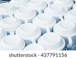 Rows of clean white upside down cups in a cafeteria or restaurant ready to serve a hot beverage, full frame background