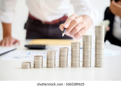 Rows of coins for finance and banking concept with business man and woman. A metaphor of international financial consulting. - Shutterstock ID 1065289625