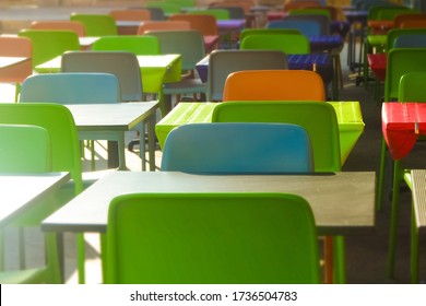 Rows of colored plastic empty tables and chairs. Empty plase without people. Financial and economic crisis. Cozy outdoor restaurant, summer terrace street cafe. Simple and cheap decoration ideas