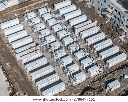 rows of containerized energy storage systems arranged at an outdoor construction site