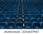 Rows of dark blue seats in empty assembly hall for performance. Front view.