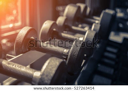 Rows of dumbbells in the gym with hign contrast and monochrome color tone