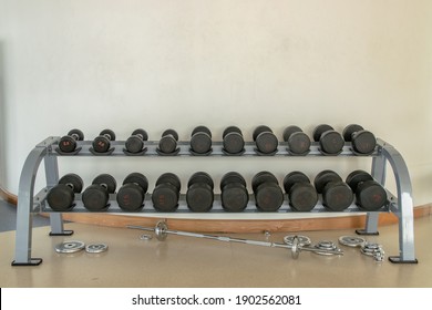 Rows of dumbbells on a rack in the fitness or gym. Weight Training Equipment. Copy space, Selective focus.