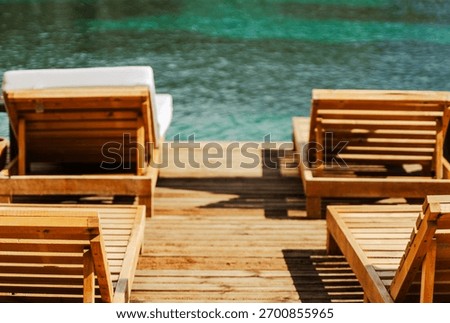 Rows of empty beach loungers on the sea pier at the resort