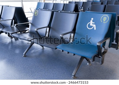 Rows of empty blue seats in public waiting area for people with physical disabilities and people with special needs
