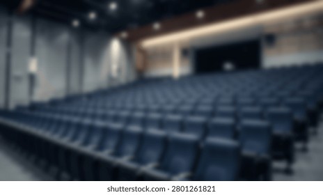 Rows of empty dark blue seats in a modern auditorium with contemporary lighting and architectural elements.