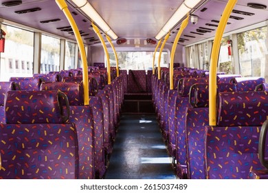 Rows of empty purple seats inside a hong kong double-decker bus, creating a vibrant and colorful interior