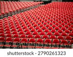Rows of empty red chairs prepared for a large event, ceremony, graduation, or public gathering inside an arena