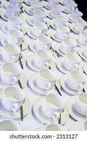 Rows of empty tea cups and saucers waiting to be filled.