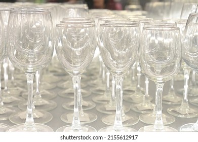 Rows Of Empty Wine Glasses Close Up. Glass Goblets On The White Table.