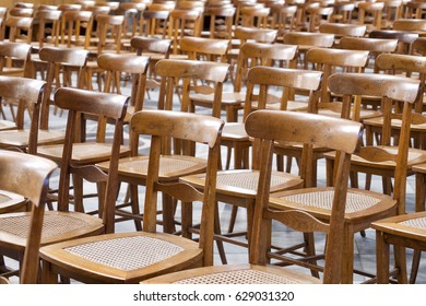 Rows Of Empty Wood And Wicker Chairs At An Event Venue In A Close Up Full Frame Background View