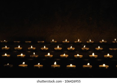Rows of firing candles in catholic church