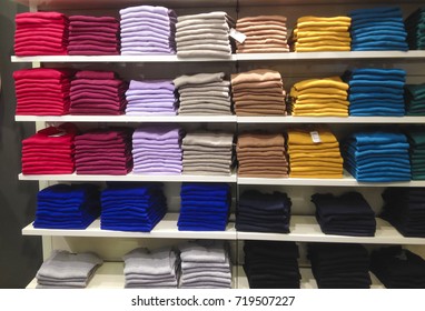 Rows of folded colorful clothes in a shop