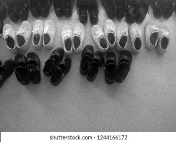 Rows Of Generic School Shoes, Some Standard Black, Others White Plimsoles.