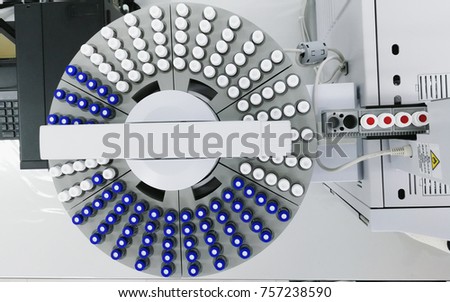 Rows of glass vials in the tray automatic liquid dispenser. Gas chromatograph.